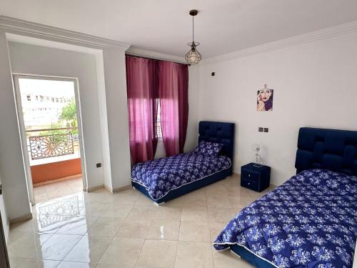 1 dormitorio con 2 camas y ventana en Appartement à beni mellal, en Beni Mellal