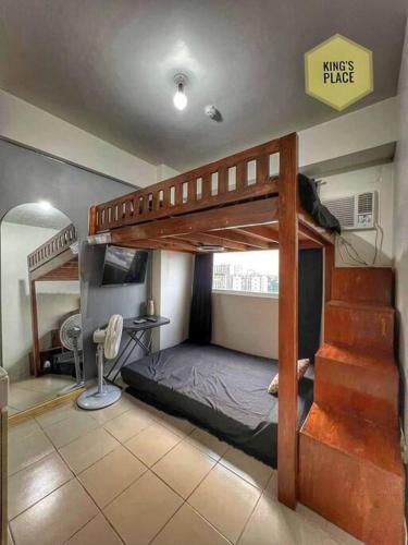 een slaapkamer met 2 stapelbedden en een bureau bij Studio type Loft bed near Ortigas in Manilla