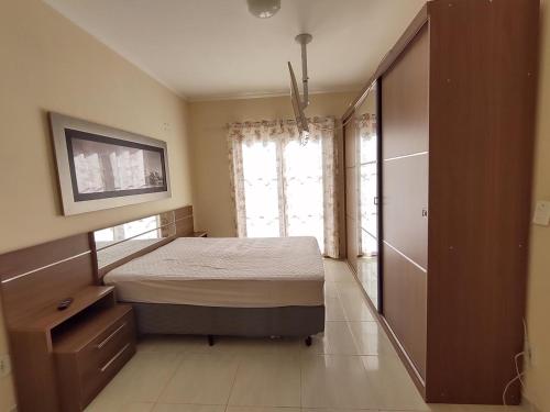 a bedroom with a bed and a large window at Um lugar para descansar e relaxar in Serra Negra