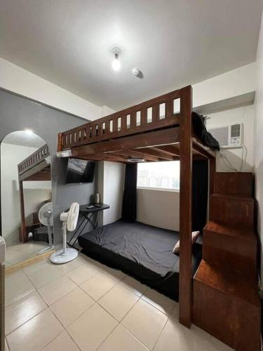 een slaapkamer met 2 stapelbedden en een spiegel bij Studio type Loft bed near Ortigas in Manilla