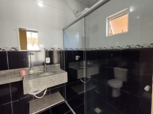 a bathroom with a sink and a toilet and a mirror at Um lugar para descansar e relaxar in Serra Negra