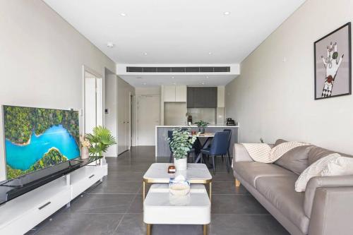 a living room with a couch and a table at Olympic Park Stadium Cozy 1 bedroom Apt in Sydney