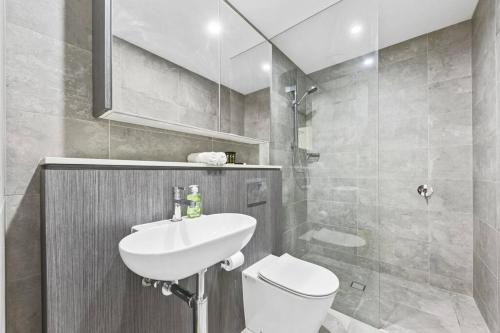 a bathroom with a sink and a toilet at Olympic Park Stadium Cozy 1 bedroom Apt in Sydney