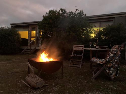 a fire pit in a yard with a table and chairs at Blue Wren Cottage Farm Stay in Yanakie