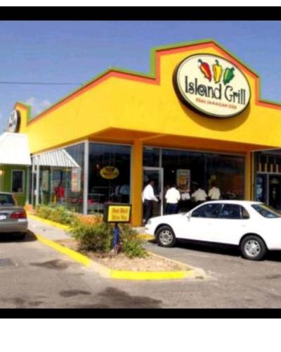a dealership with a car parked in front of a restaurant at Caribbean estate deluxe 2 in Portmore