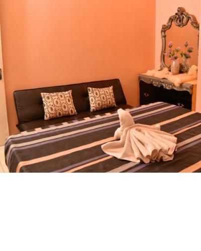 a bedroom with a couch and a towel on a bed at Caribbean estate deluxe 2 in Portmore