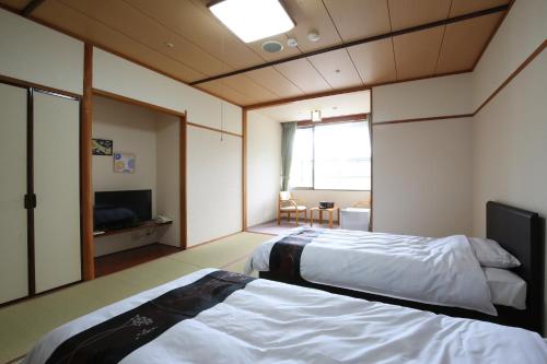 三朝町的住宿－Blancart Misasa，酒店客房设有两张床和电视。