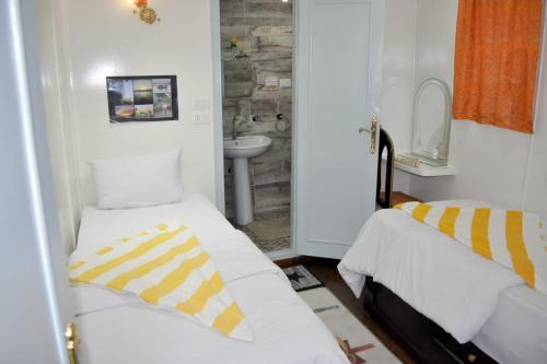 EsnaにあるMisteriのベッド2台とシンクが備わる小さな客室です。