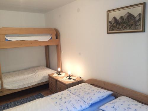 a small room with two bunk beds and a table at Apartments Pod macesnovo streho in Solčava