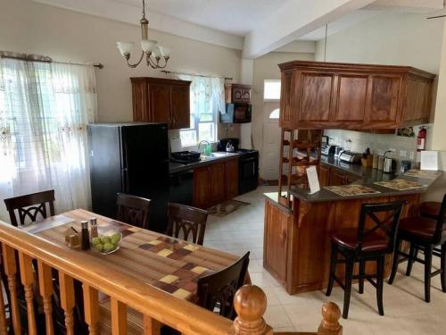 a kitchen with a table and chairs and a kitchen with a counter at The Seclusive Mansion in Roseau