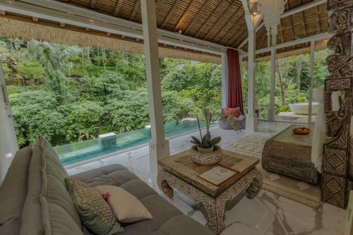 ein Wohnzimmer mit einem Sofa und einem Tisch in der Unterkunft Villa Cella Bella Ubud in Ubud