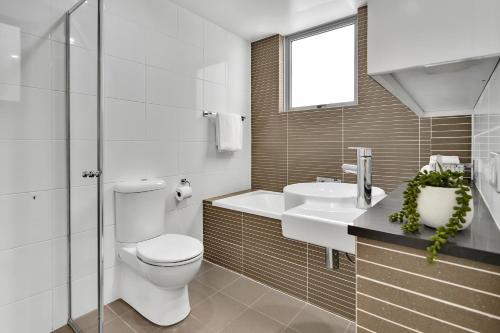 een witte badkamer met een toilet en een wastafel bij North Sydney Large Two Bedroom MIL2302 in Sydney