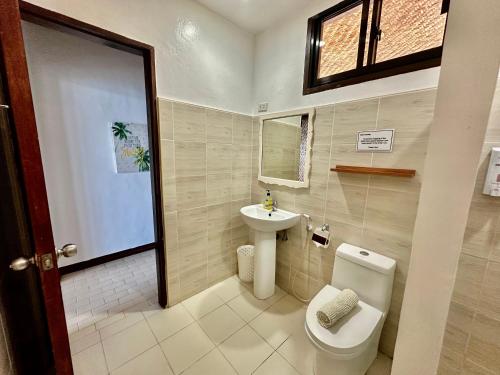 a bathroom with a toilet and a sink at Wuthering Heights Bed & Breakfast by the Sea in Dumaguete