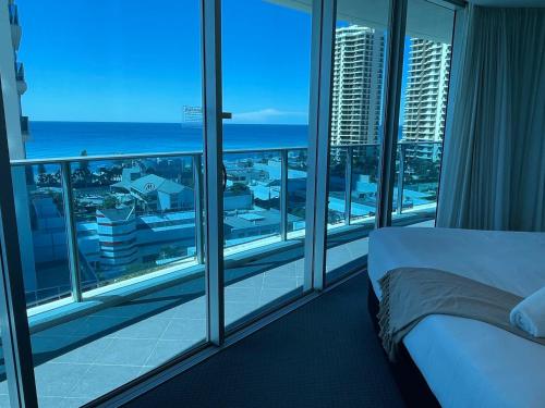 a bedroom with a bed and a view of the ocean at Number 1 H Residences - WiFi, Parking & More by Gold Coast Holidays in Gold Coast