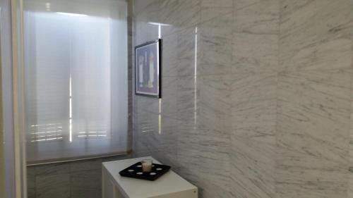 a bathroom with a white tiled wall at La Terrazza in Spoleto