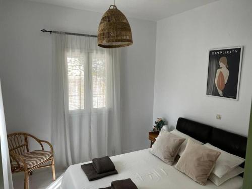 1 dormitorio con 1 cama, 1 silla y 1 ventana en Newly refurbished, coastal apartment- Barbati en Barbati