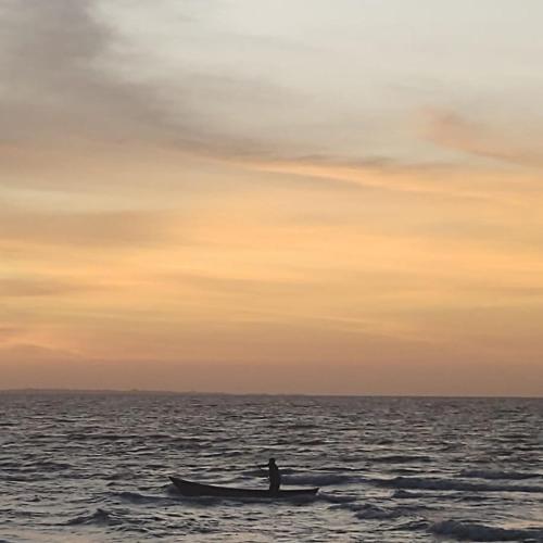 a man in a boat in the ocean at sunset at Antara del Mar in San Bernardo del Viento