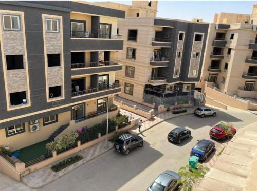 un complejo de apartamentos con coches aparcados en un aparcamiento en Dream city en El Cairo