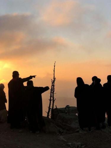 a group of people standing on a mountain at sunset at Petra Desert Dream Hotel in Wadi Musa