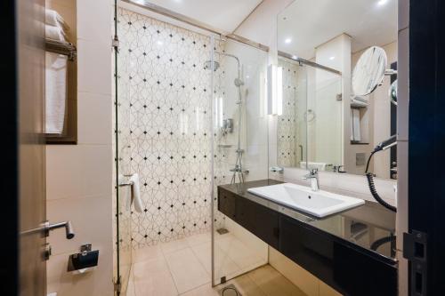 a bathroom with a sink and a shower at Orion City Hotel in Colombo