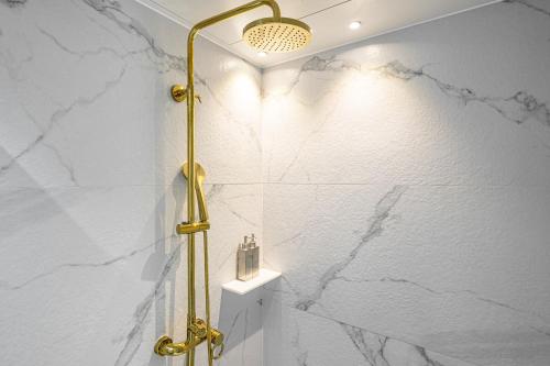 a bathroom with a shower with white marble walls at Jongno Olive Hotel in Seoul