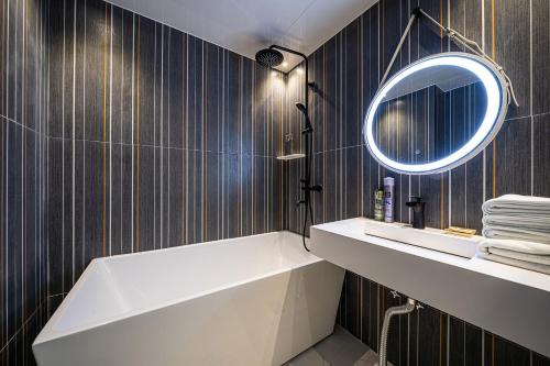 a bathroom with a tub and a sink and a mirror at Jongno Olive Hotel in Seoul