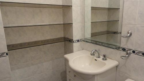 een witte badkamer met een wastafel en een spiegel bij Hostel Del Piamonte 2 in Quito