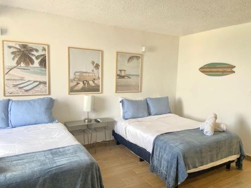 a bedroom with two beds and a table and pictures at BeachAccess HotelZone 3705 in Cancún