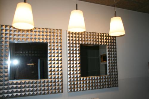 バニョラスにあるAlberg L'Astの照明付きのバスルームの壁に鏡2つ