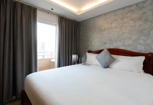 a bedroom with a large white bed and a window at Regency Grand Suites in Manila