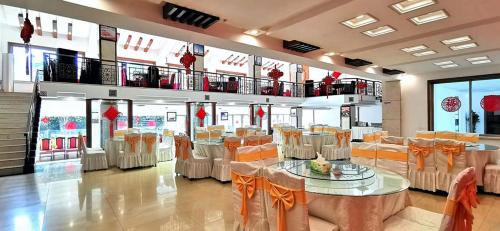 um restaurante com mesas e cadeiras num quarto em Hunan New Pipaxi Hotel em Zhangjiajie