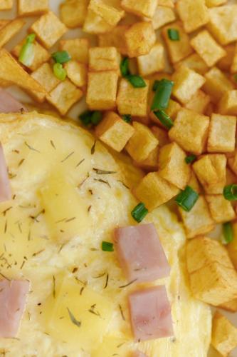 a plate of food with cheese and ham and green onions at Regency Grand Suites in Manila