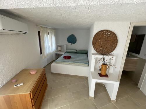 Un pequeño dormitorio con una cama y una mesa. en Villa Bella Vista, en San Teodoro
