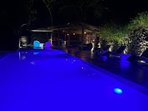 a swimming pool lit up at night with blue lights at UMA Experience in Coroico
