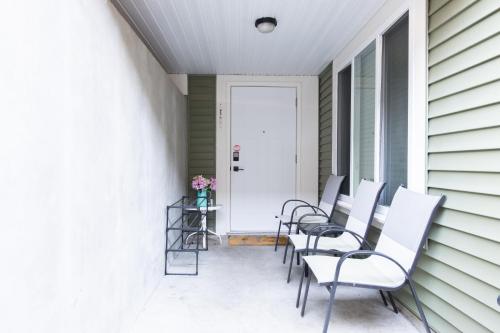 a row of chairs sitting on a porch at Modern yet comfy 3 bed suite in Surrey in Surrey