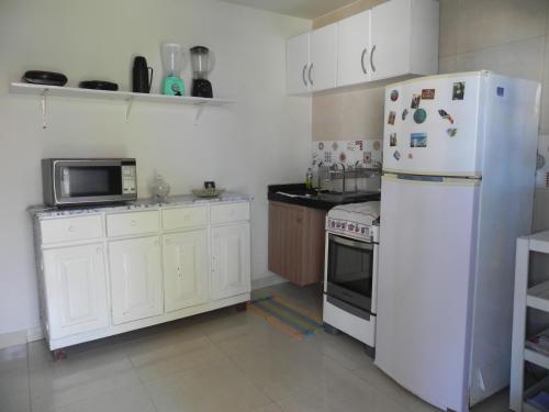 a kitchen with a white refrigerator and a microwave at Casa Paraiso Maragogi in Maragogi