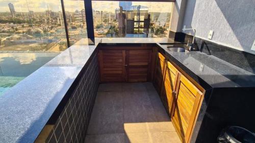 a kitchen with a sink and a large window at Reserva Madero Requinte Apto 104 in Natal