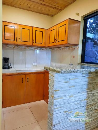 a kitchen with wooden cabinets and a counter top at Resort Sport in Independencia