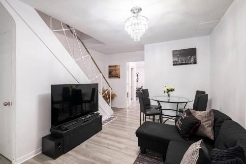 a living room with a couch and a tv and a table at Harmony Home Near University of Waterloo in Waterloo