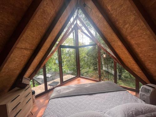 uma cama num quarto com uma grande janela em UMA Experience em Coroico
