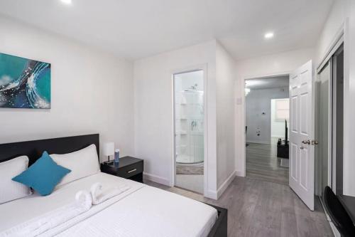 um quarto com uma cama branca e uma almofada azul em Harmony Home Near University of Waterloo em Waterloo