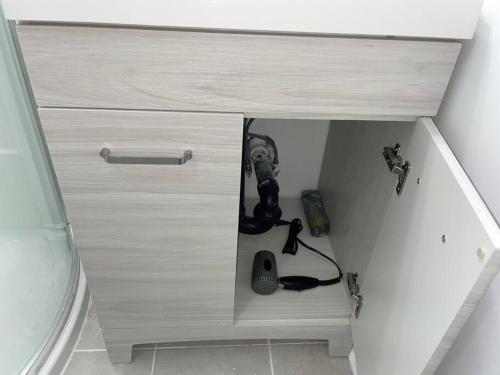 a wooden cabinet with a drawer with a screwdriver and other things at Harmony Home Near University of Waterloo in Waterloo
