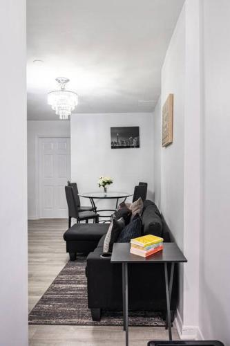 a living room with a black couch and a table at Harmony Home Near University of Waterloo in Waterloo