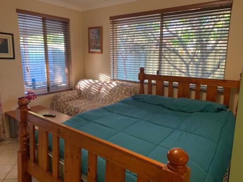 um quarto com uma cama de madeira e um sofá em lovey studio with bathroom and kitchen em Perth