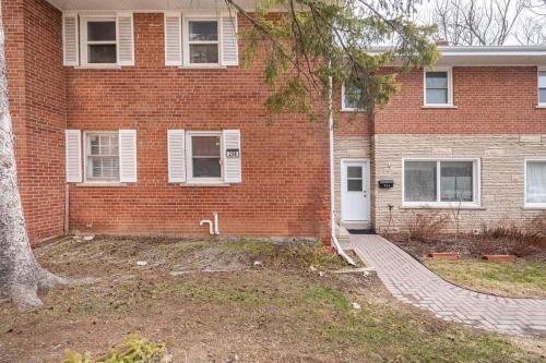 a brick building with a white door and a tree at Harmony Home Near University of Waterloo in Waterloo