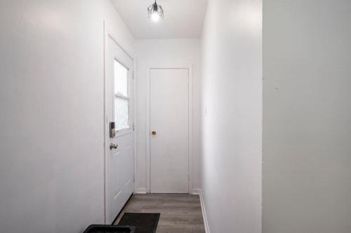 a hallway with a white door and a window at Harmony Home Near University of Waterloo in Waterloo