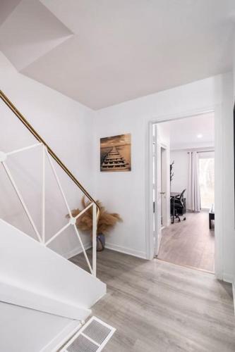 a white hallway with a staircase in a house at Harmony Home Near University of Waterloo in Waterloo