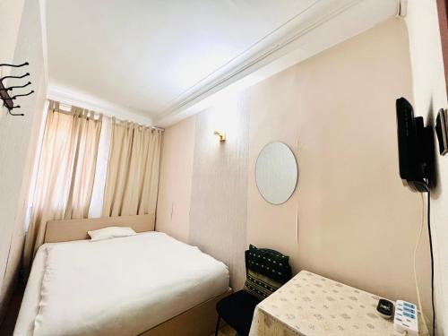 a small room with a bed and a table at Khongor Guest house & Tours in Ulaanbaatar