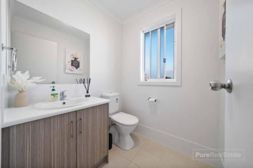 La salle de bains est pourvue d'un lavabo, de toilettes et d'une fenêtre. dans l'établissement Beachfront Sunny Dais, à Port Vincent