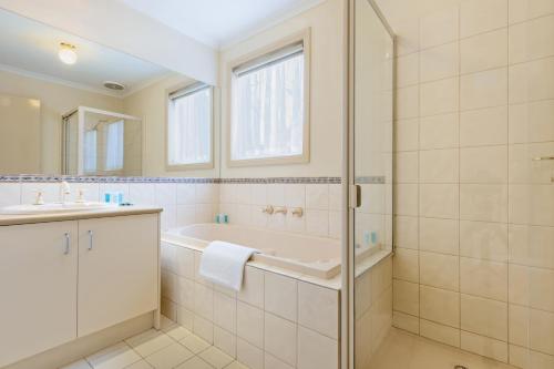 a bathroom with a tub and a sink and a shower at Park Avenue - Forest Hill in Forest Hill